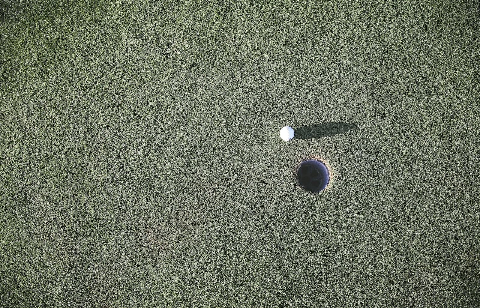 white golf ball near hole
