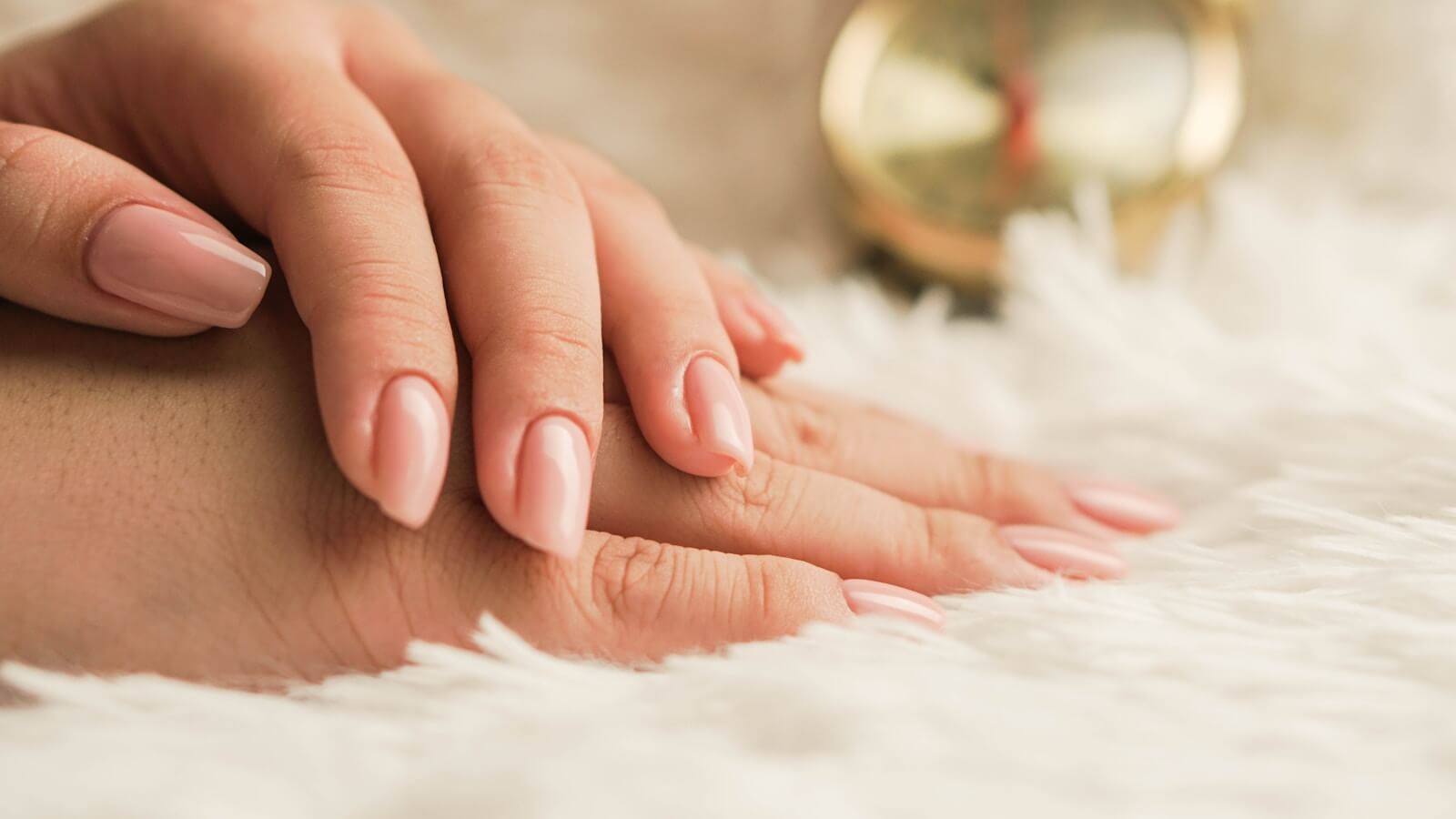 manicure: persons hand on white textile