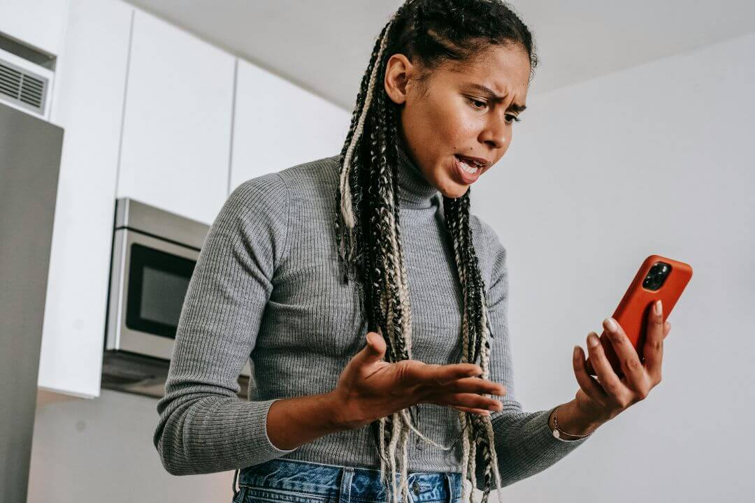 a woman getting annoyed by some small thing she sees on the phone screen